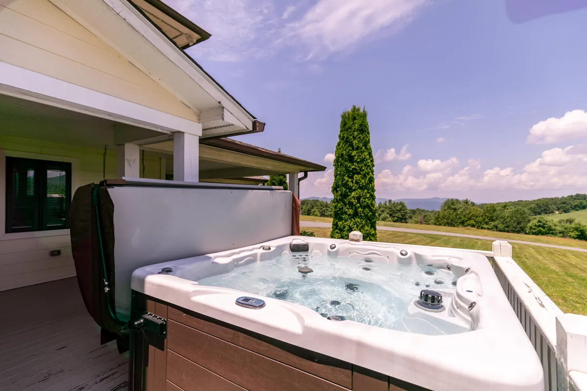 This exterior image showcases a hot tub set amidst natural scenery, with open sky and landscape in view. The atmosphere is tranquil and relaxing—perfect for unwinding after an active day of family adventures.