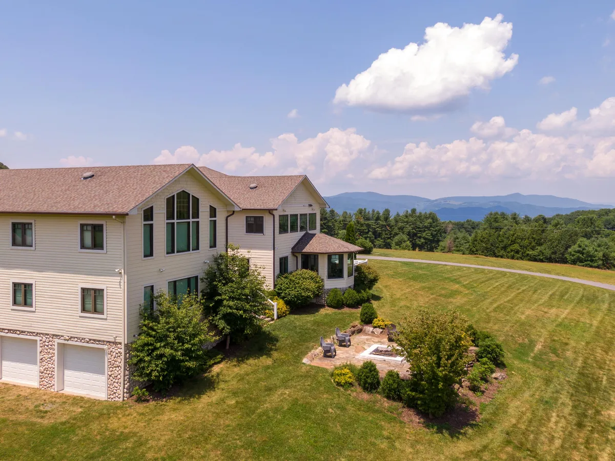 An exterior shot of the house and its outdoor seating area, surrounded by scenic landscape. The inviting setup suggests a tranquil space for family gatherings, games, and relaxation, with the house acting as a cozy home base for all ages.